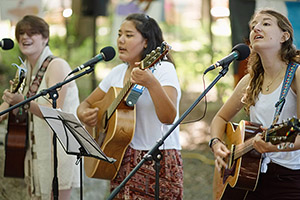 three songleaders singing and playing guitar