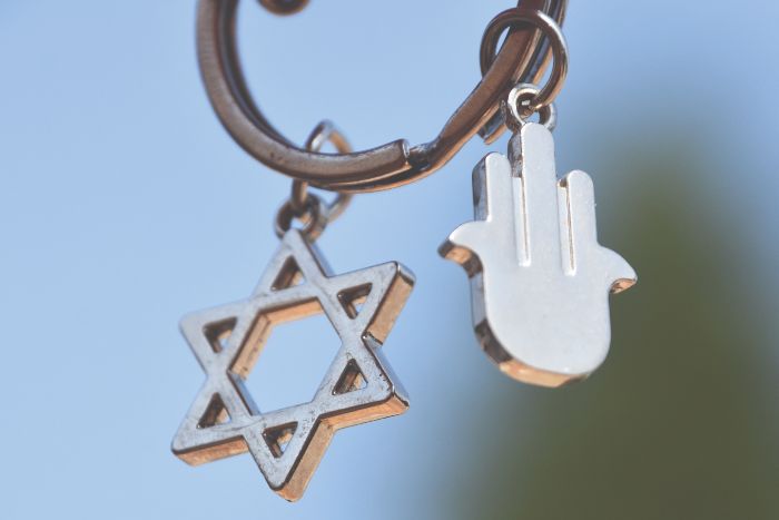 Silver star of David and a hamsa hanging from a key ring 