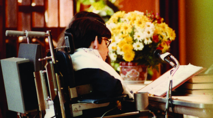 Jeff Erlanger in his electric wheelchair reading Torah from the pulpit