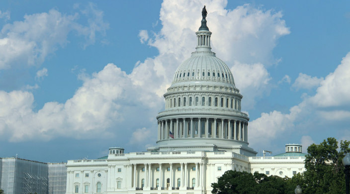 US Capitol building against a cloudy blue sky