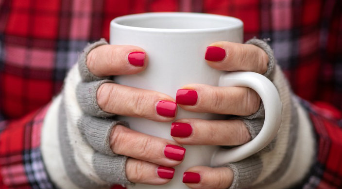 Womans hands holding a mug 