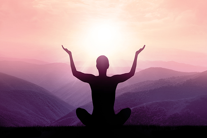 person doing yoga in the mountains at sunrise