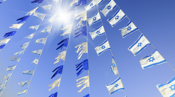 Israeli flags and blue streamers on a wire in the sunlight