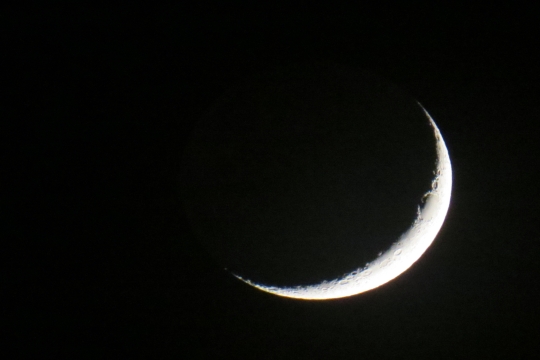 Waning crescent moon on black background