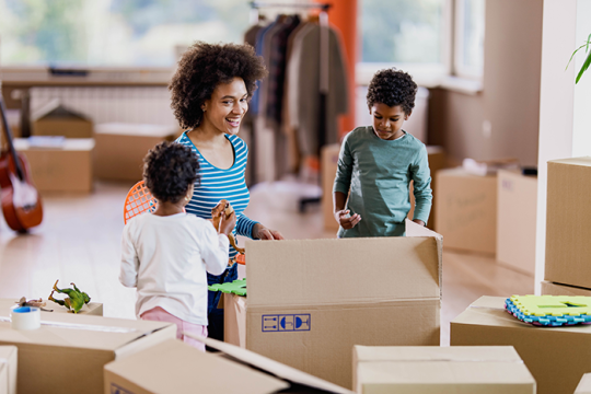 Photo of a mother and two kids uppacking boxes